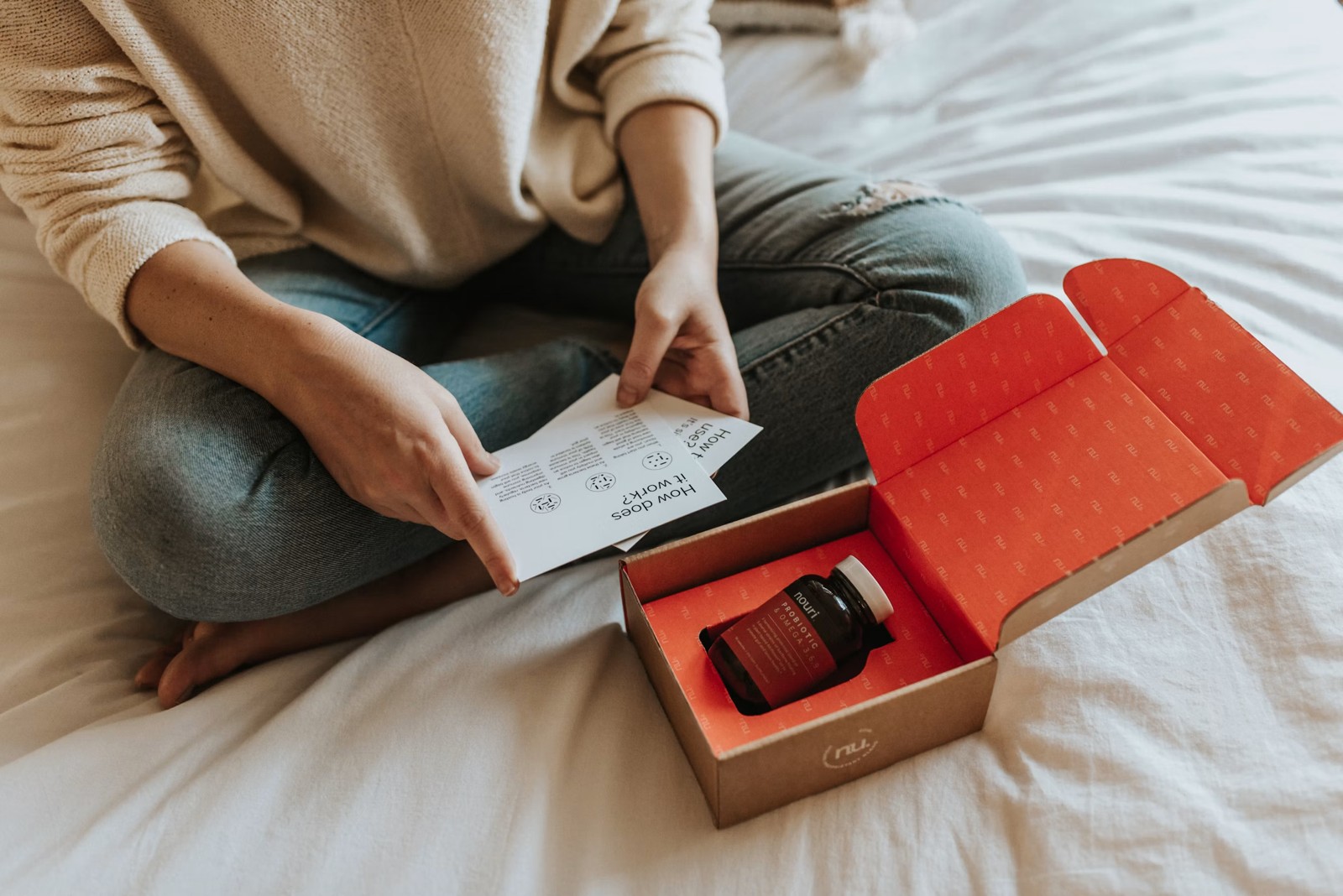 A person checking a document beside an open package